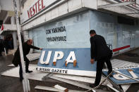 <p>Men hold up the sign of Turkish Cypriot newspaper Afrika, which was attacked by supporters of Turkish President Tayyip Erdogan on Monday over the newspaper’s headlines criticising the Turkish army’s campaign in Afrin in northern Syria, in the Turkish-administered northern part of Nicosia, Cyprus, Jan. 22, 2018. (Photo: Yiannis Kourtoglou/Reuters) </p>