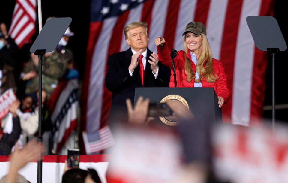 US President Donald Trump claps as Republican incumbent senator Kelly Loeffler speaks during a rally ahead of Senate the runoff in Dalton, Georgia on January 4, 2021. - President Donald Trump, still seeking ways to reverse his election defeat, and President-elect Joe Biden converge on Georgia on Monday for dueling rallies on the eve of runoff votes that will decide control of the US Senate. Trump, a day after the release of a bombshell recording in which he pressures Georgia officials to overturn his November 3 election loss in the southern state, is to hold a rally in the northwest city of Dalton in support of Republican incumbent senators Kelly Loeffler and David Perdue. (Photo by SANDY HUFFAKER / AFP) (Photo by SANDY HUFFAKER/AFP via Getty Images)