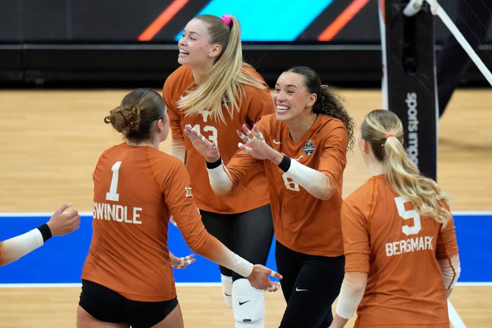 Texas's Madisen Skinner celebrates a point against Nebraska with Ella Swindle, left, Bella Bergmark, right, and Jenna Wenaas during the championship match in the NCAA Division I women's college volleyball tournament Sunday in Tampa, Fla.