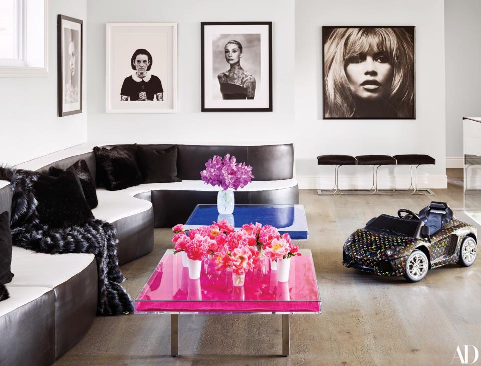 Yves Klein blue and pink pigment cocktail tables add a pop of color to the second-floor landing. Pink and white glass tumblers by Maison Midi. Artwork from left to right: Cheyenne Randall (3): Douglas Kirkland/Courtesy of Fahey/Klein Gallery.