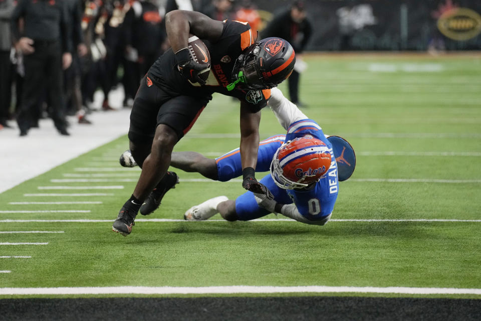 Oregon State running back Jam Griffin (8) breaks a tackle attempt by Florida safety Trey Dean III (0) before scoring a touchdown during the second half of the Las Vegas Bowl NCAA college football game Saturday, Dec. 17, 2022, in Las Vegas. (AP Photo/John Locher)