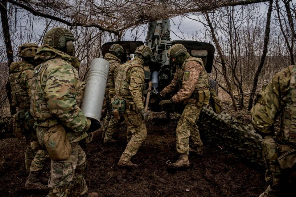 Ukrainian servicemen load a 152 mm shell into a Msta-B howitzer to fire towards Russian positions, near the frontline town of Bakhmut on March 2 (AFP via Getty Images)