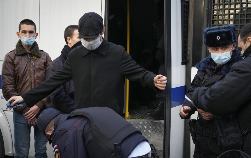 Police officer searches a detained man in Moscow, Russia, Thursday, Nov. 4, 2021. The Moscow authorities banned their traditional "Russian March" in Moscow celebrating People's Unity Day due to the coronavirus epidemic. (AP Photo/Alexander Zemlianichenko)