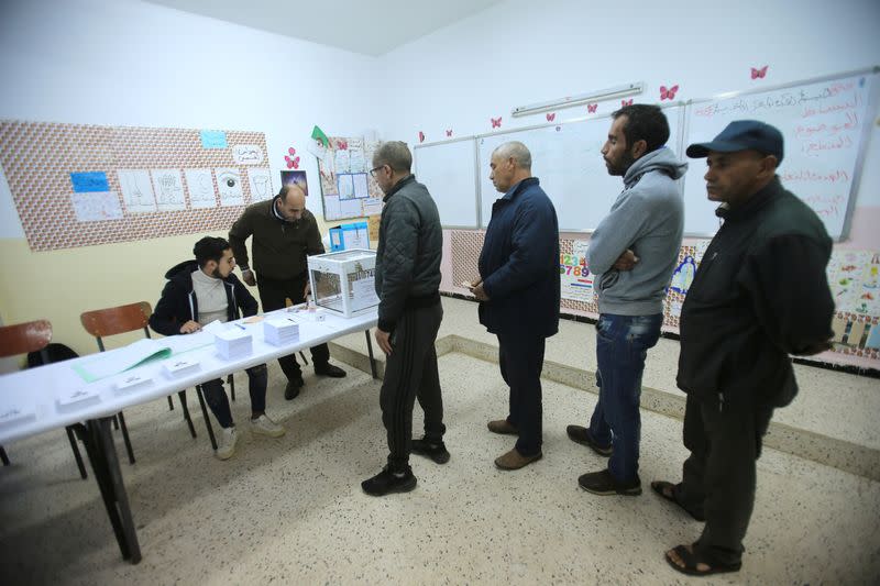 Voters wait to receive ballots at a polling station during the presidential election in Algiers