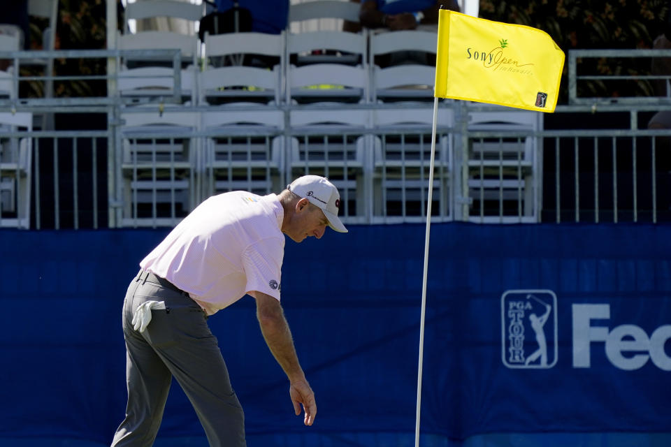 Jim Furyk reaches for his ball after hitting a hole-in-one on the 17th hole during the first round of the Sony Open golf tournament, Thursday, Jan. 13, 2022, at Waialae Country Club in Honolulu. (AP Photo/Matt York)