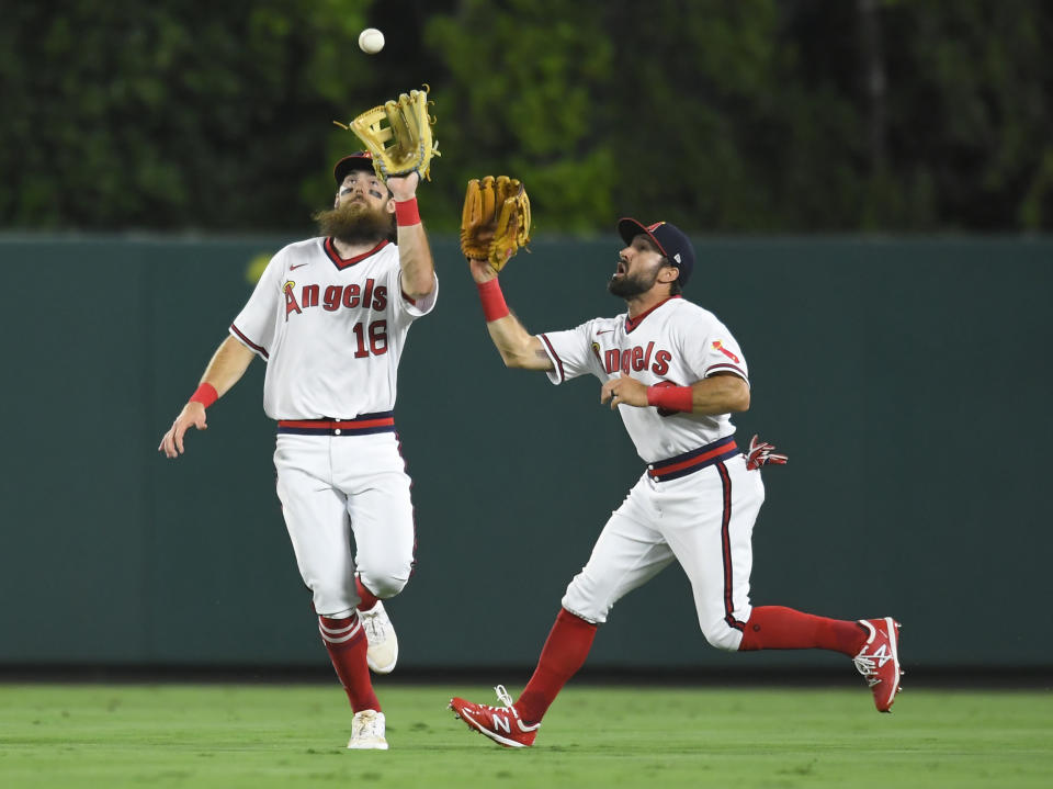 Los Angeles Angels center fielder Brandon Marsh, left, runs in front of right fielder Adam Eaton to catch a fly ball hit by Oakland Athletics' Jed Lowrie in the eighth inning of a baseball game against Friday, July 30, 2021, in Anaheim, Calif. (AP Photo/John McCoy)