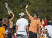 Tampa Bay Buccaneers NFL football quarterback Tom Brady, right, waves as an unidentified boy holds the Lombardi Trophy as he and others celebrate their Super Bowl 55 victory over the Kansas City Chiefs with a boat parade in Tampa, Fla., Wednesday, Feb. 10, 2021. (Dirk Shadd/Tampa Bay Times via AP)