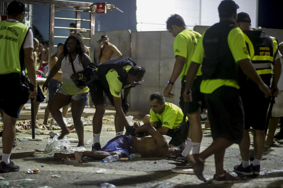 Police officers detain a man during clashes between police and party-goers after the official start of Carnival, on Copacabana beach, Rio de Janeiro, Brazil, Sunday, Jan. 12, 2020. Police officers and municipal guards dispersed attendees with gas bombs, and moments of tension were experienced in the deconcentration of the event, which brought together hundreds of thousands of people. (AP Photo/Bruna Prado)