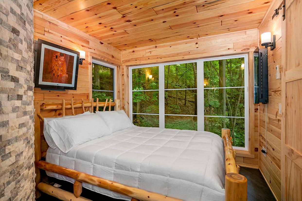 A primary bedroom in the Winding Springs treehouse at Tree Vistas resort in Ionia Township, Michigan.