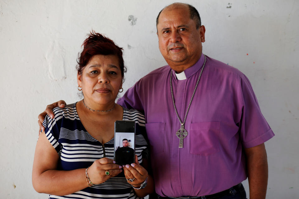 Rev. Irma de Alvarado and Bishop David Alvarado, of the Anglican Episcopal Church in El Salvador, show a picture of their son Josue Alvarado Guerra, who was apprehended by U.S. authorities in November 2019.&nbsp; (Photo: Jose Cabezas/Reuters)