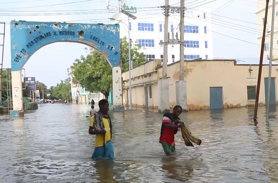 In this image made from video, residents move through floodwaters on a street in the town of Beledweyne, in Somalia Sunday, Nov. 19, 2023. First, some families fled drought and violence. Now they say they have nowhere to hide from intense flooding as rainfall exacerbated by the weather phenomenon El Nino pummels large parts of Somalia. (AP Photo)