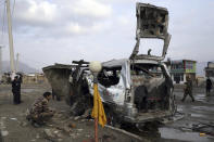 Security personnel inspect the site of a deadly bomb attack in Kabul, Afghanistan, Sunday, March 7, 2021. The bomb attached to minibus exploded Sunday in the capital, Kabul, killing and wounding several people. (AP Photo/Rahmat Gul)