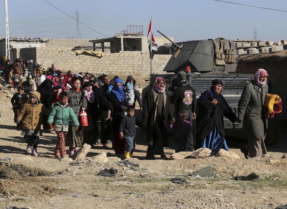 Iraquíes desplazados huyen de sus viviendas debido a los combates entre las fuerzas de seguridad de Irak y extremistas del grupo Estado Islámico, en el vecindario Mamun en el sector occidental de Mosul, Irak, el sábado 25 de febrero de 2017. (AP Foto/Khalid Mohammed)