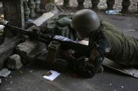 A government soldier takes up position with a machinegun on the porch of a house during fighting with Muslim rebels from the Moro National Liberation Front (MNLF) in Zamboanga city in southern Philippines September 15, 2013. (REUTERS/Erik De Castro)