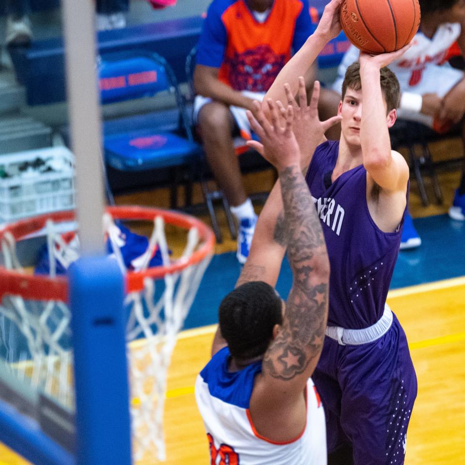 Nate McGill (32) of Northern York shoots over York High's Marquise McClean (20) during the 5A district third-place game, February 28, 2019. The Bearcats defeated the Polar Bears 86 to 68.