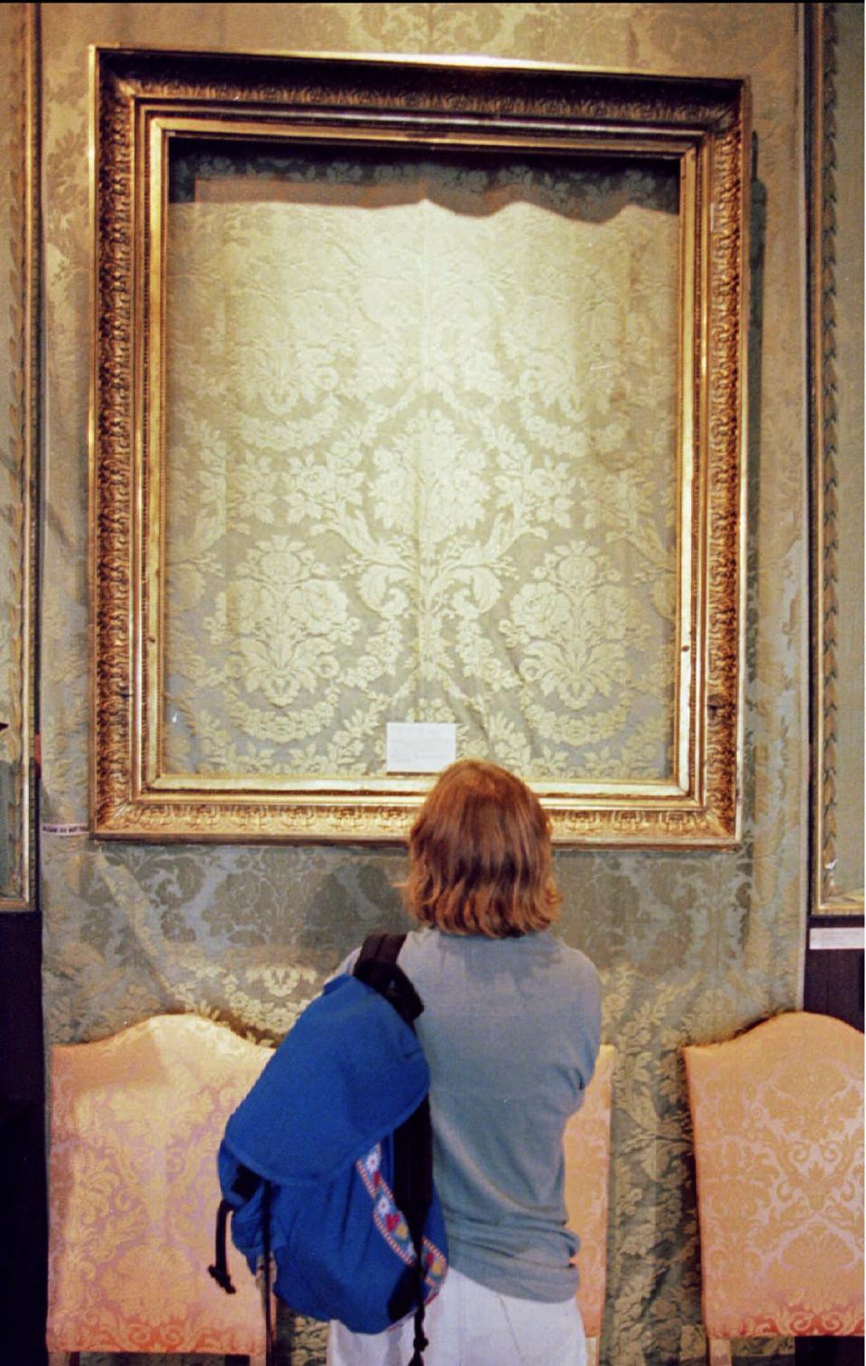 A visitor looks at the frame that held Rembrandt Van Rijn's painting "Lady and Gentleman in Black" at the Isabella Stewart Gardner Museum in Boston in this file photo taken August 29, 1990. The painting was one of 13 artworks stolen from the museum March 18, 1990 in one of the largest art heists ever. Twenty-five years have passed since 13 artworks worth $500 million were stolen from Boston's Isabella Stewart Gardner Museum and the costliest art theft in U.S. history remains unsolved. To match story USA-BOSTON/GARDNER REUTERS/Stringer/Files (UNITED STATES - Tags: CRIME LAW ENTERTAINMENT)
