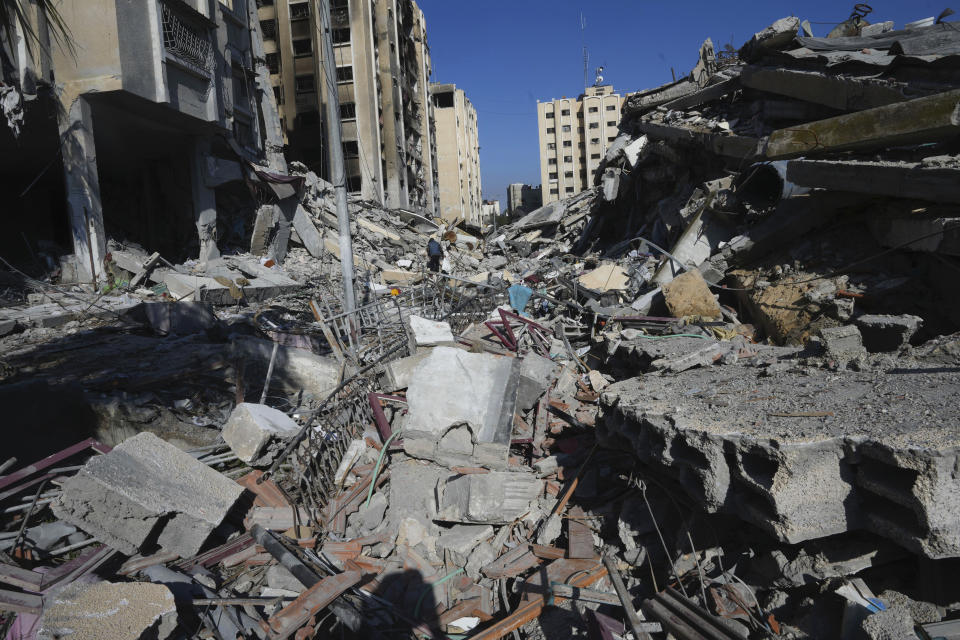 A Palestinian walks through destruction from the Israeli bombardment in the Nusseirat refugee camp in Gaza Strip, Friday, Jan. 19, 2024. (AP Photo/Adel Hana)