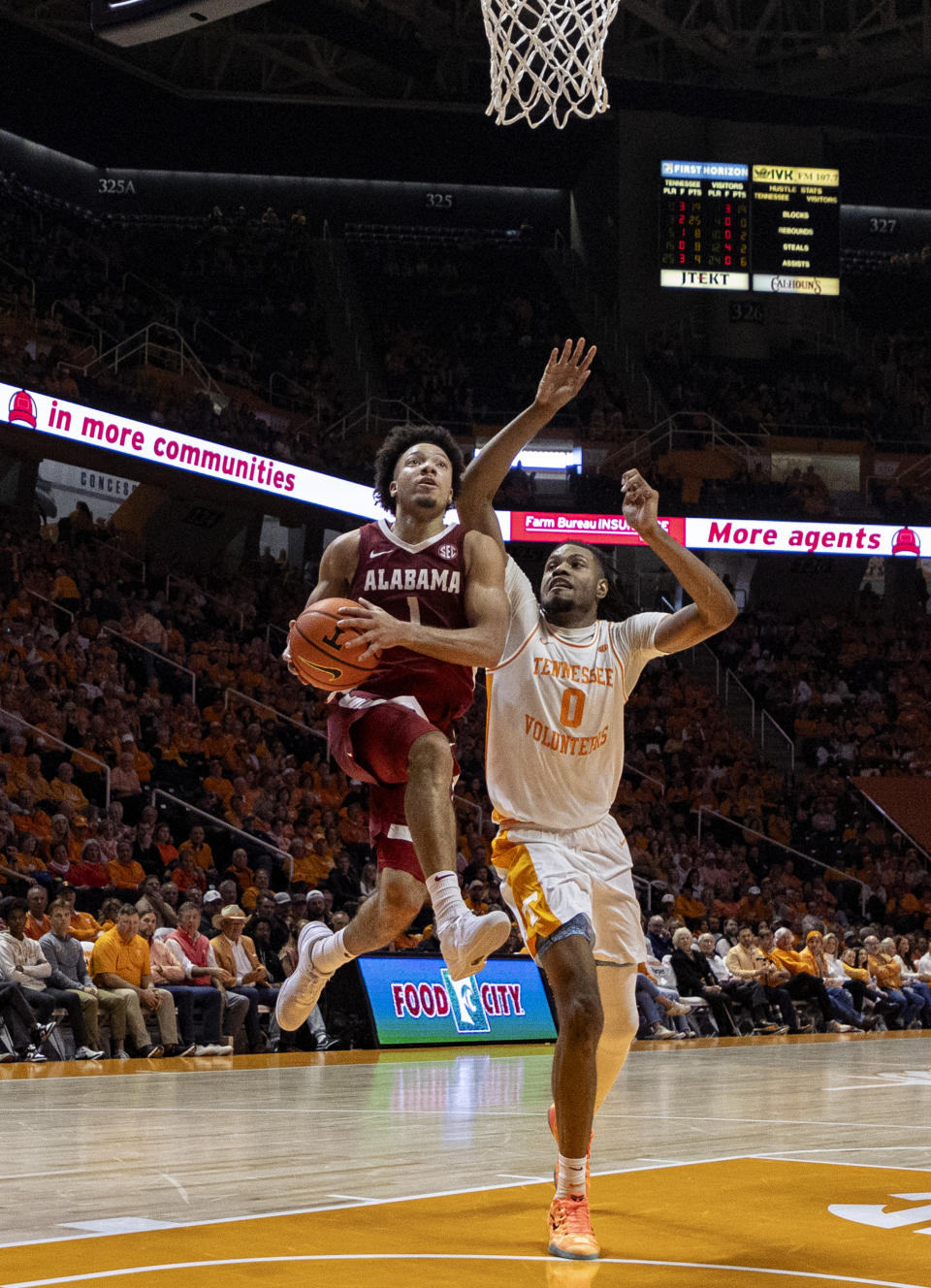 Alabama guard Mark Sears (1) goes for a shot past Tennessee forward Jonas Aidoo (0) during the second half of an NCAA college basketball game Saturday, Jan. 20, 2024, in Knoxville, Tenn. (AP Photo/Wade Payne)