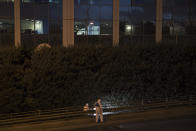 Greek forensic experts search at the scene after a powerful bomb exploded outside private Greek television station, in Faliro, Athens, Monday, Dec, 17, 2018. Police said the blast occurred outside the broadcasters' headquarters near Athens after telephoned warnings prompted authorities to evacuate the building, causing extensive damage but no injuries. (AP Photo/Petros Giannakouris)