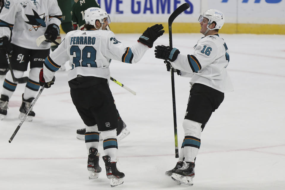 San Jose's Mario Ferraro (38) high fives teammate San Jose's Ryan Donato (16) after Donato scored a goal in the first period of an NHL hockey game against the Minnesota Wild, Sunday, Jan. 24, 2021, in St. Paul, Minn. (AP Photo/Stacy Bengs)