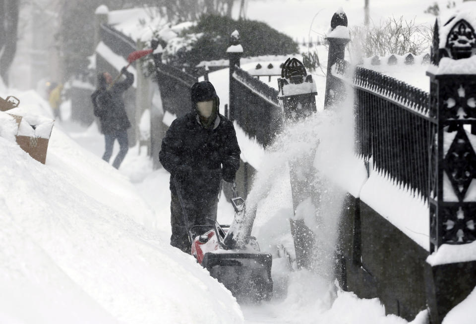 FILE - Workers clear snow from a sidewalk in a residential area near the Statehouse on Beacon Hill, Monday, Feb. 9, 2015, in Boston. For much of the Eastern United States, the winter of 2023 has been a bust. Snow totals are far below average from Boston to Philadelphia in 2023 and warmer temperatures have often resulted in more spring-like days than blizzard-like conditions. (AP Photo/Steven Senne, File)