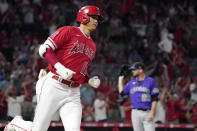 Los Angeles Angels' Shohei Ohtani, left, rounds first after hitting a two-run home run as Colorado Rockies starting pitcher Austin Gomber waits for another ball during the sixth inning of a baseball game Tuesday, July 27, 2021, in Anaheim, Calif. (AP Photo/Mark J. Terrill)