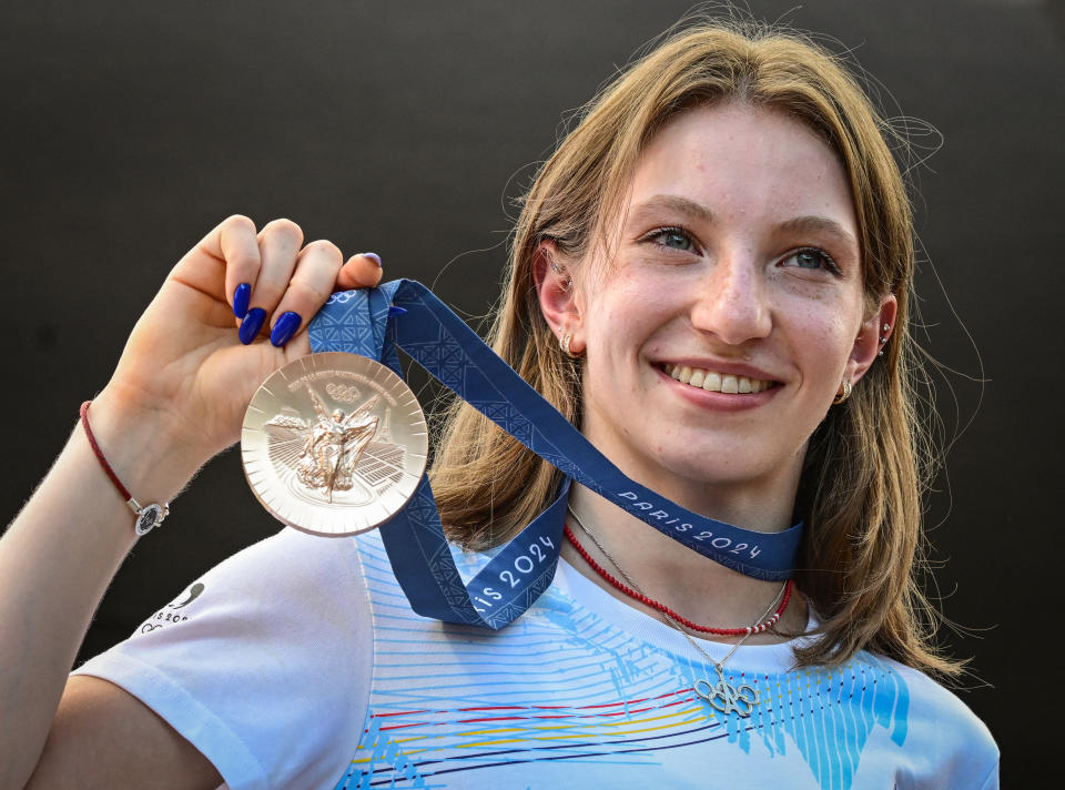 Romanian gymnast Ana Maria Barbosu poses with her Olympic bronze medal she was given on August 16, 2024 in Bucharest, Romania, after a gymnast from the US was stripped of it. Barbosu was awarded the Olympic floor exercise bronze medal originally given to Jordan Chiles, following a decision by the International Olympic Committee (IOC). The IOC decision followed a Court of Arbitration for Sport (CAS) ruling which cancelled the re-evaluation of Chiles' score on the grounds that the appeal of her degree of difficulty was lodged by the US team four seconds after the regulatory deadline, set at one minute. (Photo by Daniel MIHAILESCU / AFP) (Photo by DANIEL MIHAILESCU/AFP via Getty Images)