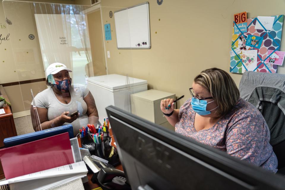 Macomb County Rotating Emergency Shelter Team (MCREST) case manager Kristin Lawrence (right) works to help Quantanique Anderson of Detroit with searching for affordable housing through their program in Macomb County on July 26, 2021 at the MCREST building in Roseville.