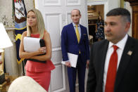 President Donald Trump's White House Senior Adviser Stephen Miller, center, stands in the Oval Office of the White House during a law enforcement briefing on the MS-13 gang, Wednesday, July 15, 2020, in Washington. Standing at left is White House press secretary Kayleigh McEnany. (AP Photo/Patrick Semansky)