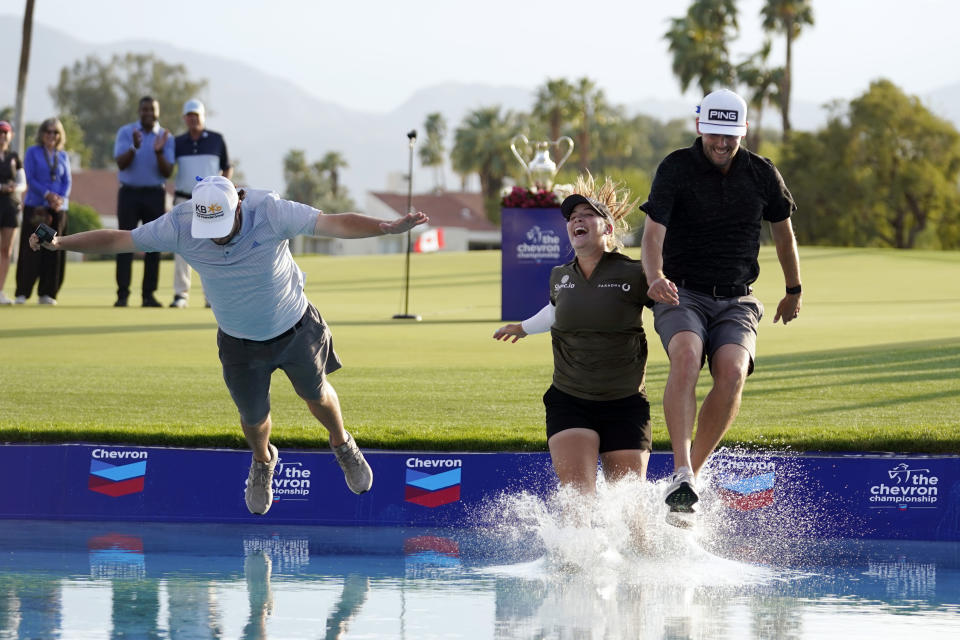 FILE - Jennifer Kupcho, center, jumps in the water with her husband Jay Monahan, right, and caddie David Eller after Kupcho's win in the LPGA Chevron Championship golf tournament Sunday, April 3, 2022, in Rancho Mirage, Calif. The major has left after 40 years in California for a new site in the Houston area. (AP Photo/Marcio Jose Sanchez, File)