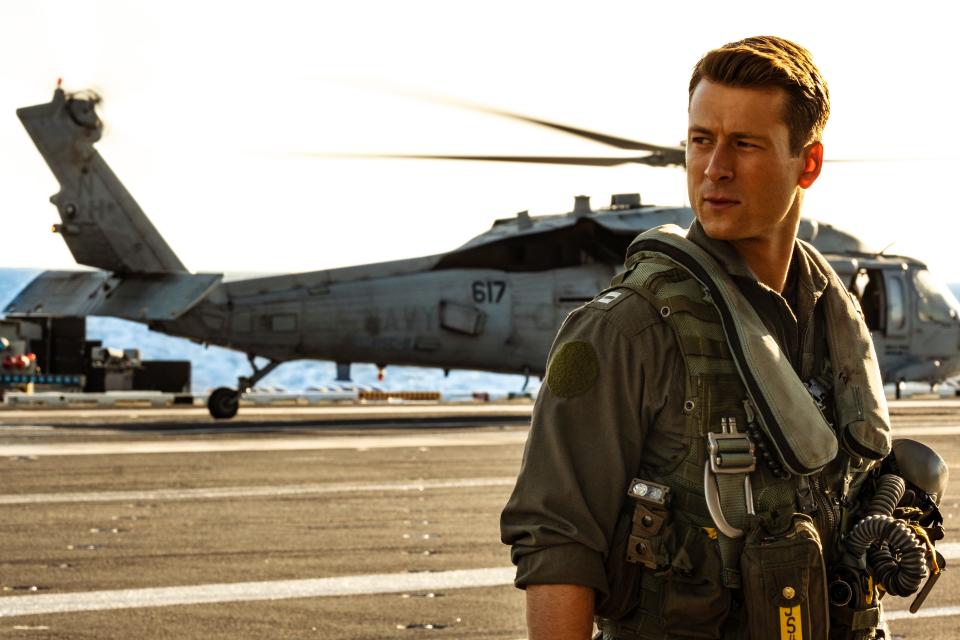 Glen Powell standing on an aircraft carrier