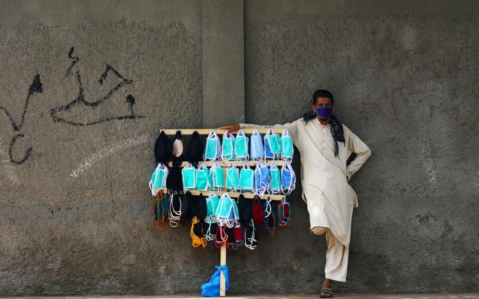 A man sells protective face masks during partial lockdown in Karachi, Pakistan - SHAHZAIB AKBER/EPA-EFE/Shutterstock