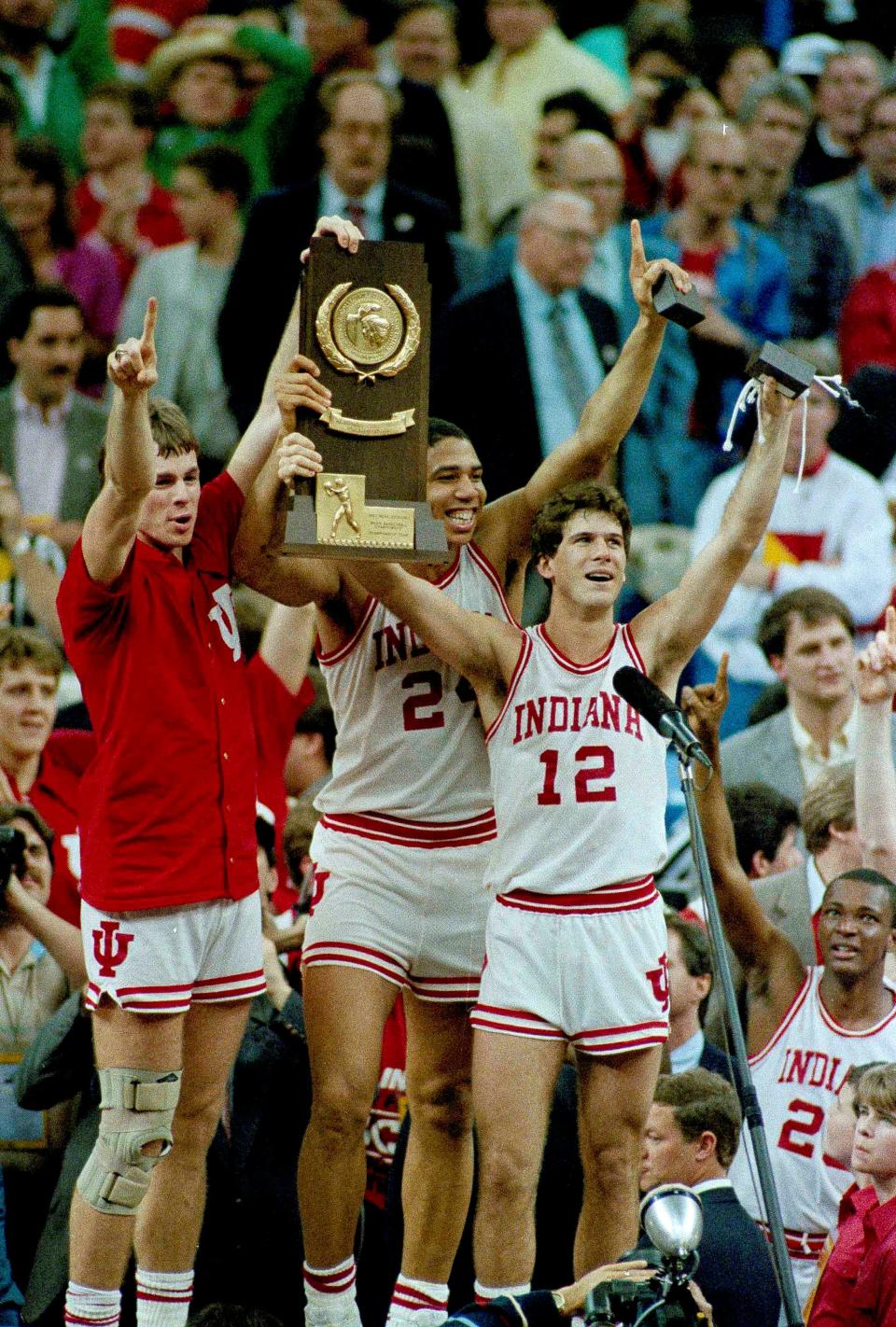 Indiana players Todd Meier, left, Daryl Thomas, center, and Steve Alford hold the trophy as they celebrate their winning the NCAA Championship over Syracuse in New Orleans Monday, March 30, 1987. The three are the team's seniors and co-captions. (AP Photo/Bill Haber)