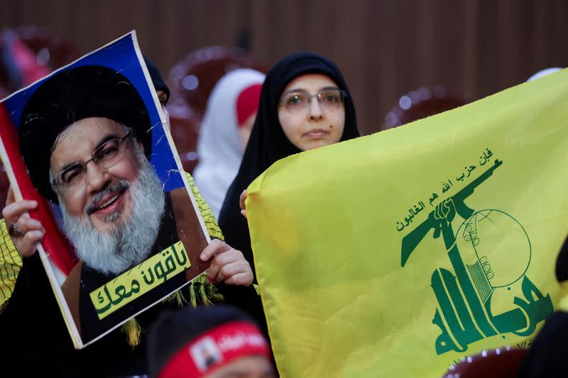 FILE PHOTO: Lebanon's Hezbollah supporters carry a flag and a picture of Hezbollah leader Sayyed Hassan Nasrallah during a rally marking al-Quds Day, in Beirut's southern suburbs