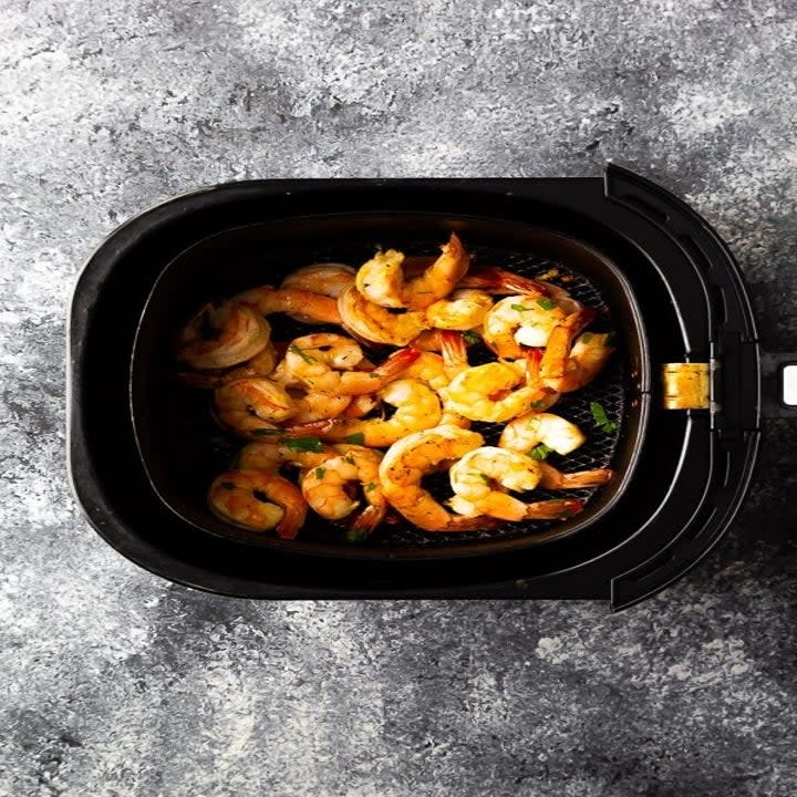 Honey lime shrimp in an air fryer basket.