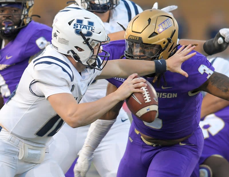 Utah State quarterback McCae Hillstead, front left, tries to scramble away from James Madison defensive lineman Mikail Kamara (3) during the first half of an NCAA college football game Saturday, Sept. 23, 2023, in Logan, Utah. (Eli Lucero/The Herald Journal via AP) | Eli Lucero/The Herald Journal via AP