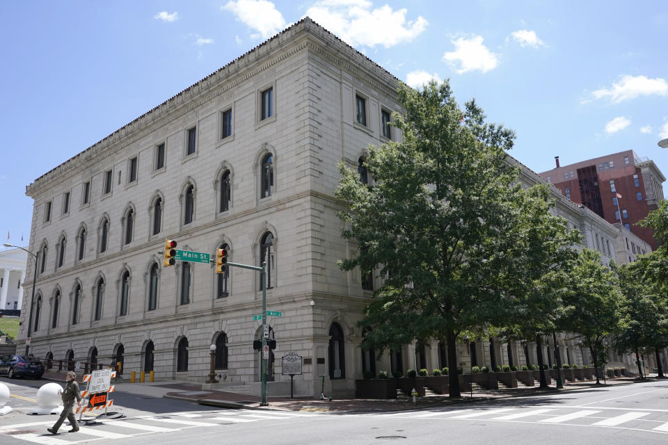 FILE - A pedestrian passes by the US 4th Circuit Court of Appeals Courthouse on Main Street in Richmond, Va., Wednesday, June 16, 2021. West Virginia's transgender sports ban violates the rights of a teen athlete under Title IX, the federal civil rights law that prohibits sex-based discrimination in schools, an appeals court ruled Tuesday, April 16, 2024. The 4th U.S. Circuit Court of Appeals ruled 2-1 that the law cannot be applied to a 13-year-old who has been taking puberty-blocking medication and publicly identified as a girl since she was in the third grade. (AP Photo/Steve Helber, File)