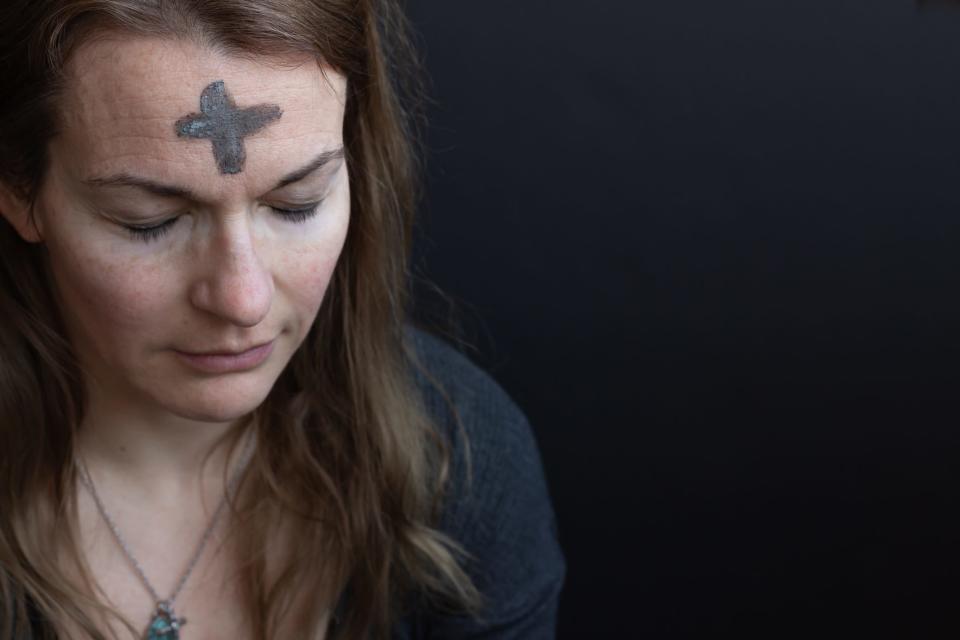 Woman with ash cross on forehead for Ash Wednesday.