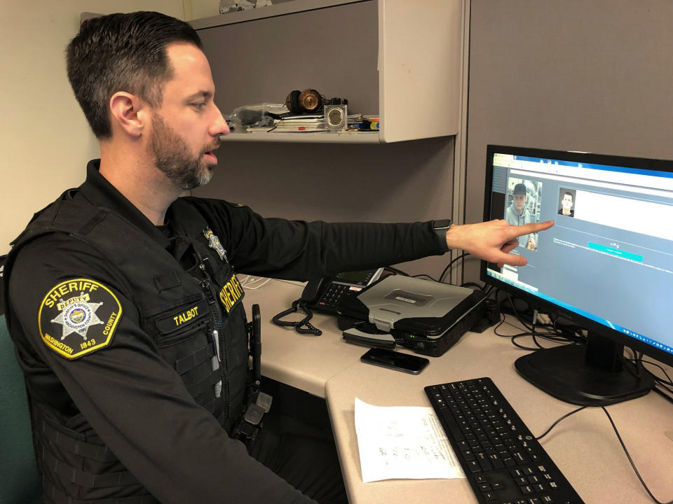 FILE - In this Feb. 22, 2019, file photo, Washington County Sheriff's Office Deputy Jeff Talbot demonstrates how his agency used facial recognition software to help solve a crime, at their headquarters in Hillsboro, Ore. The image on the left shows a man whose face was captured on a surveillance camera and investigators used the software to scan their database of past mug shots to match that facial image with an identity. Amazon said Wednesday, June 10, 2020, it will ban police use of its facial recognition technology for a year in order to give Congress time to come up with ways to regulate the technology. (AP Photo/Gillian Flaccus, File)