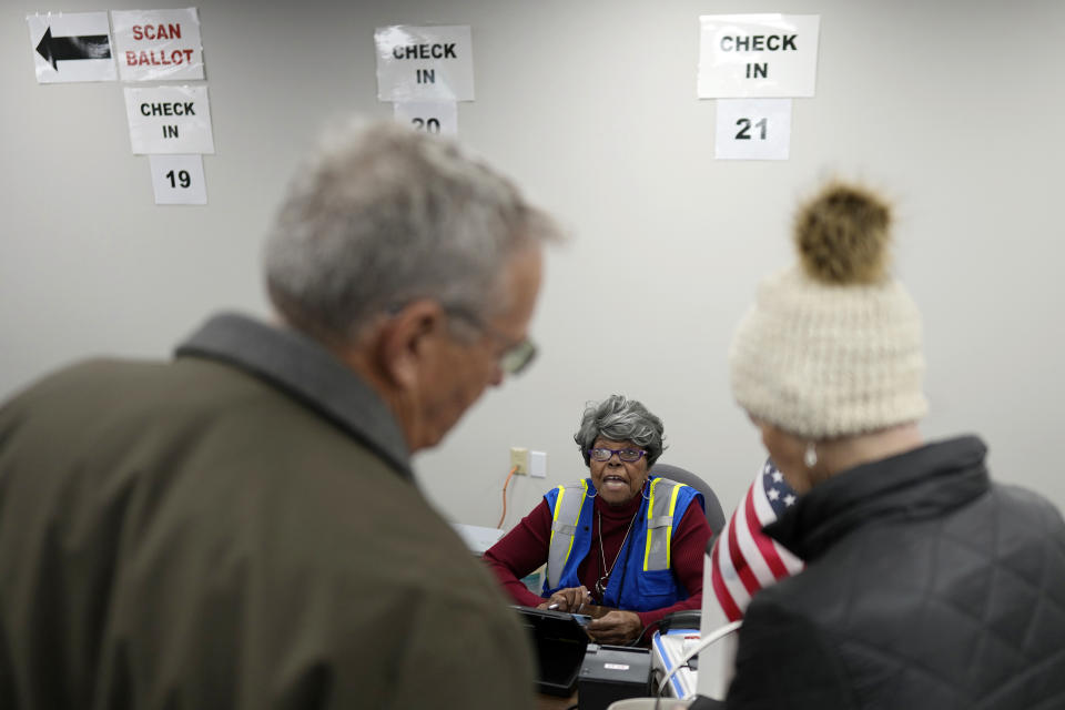 Hamilton County Board of Elections volunteer Elaine Southerland helps voters sign in as they arrive for early in-person voting at the Hamilton County Board of Elections in Cincinnati, Thursday, Nov. 2, 2023. (AP Photo/Carolyn Kaster)