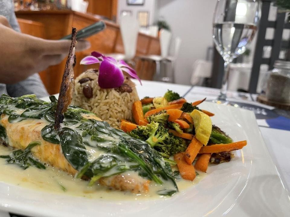 Oven roasted Salmon with coconut milk and spinach served at Sodade Restaurant at 1145 Main St., Brockton on Nov. 21, 2021.