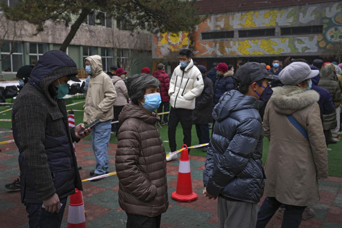 Residents wearing face masks to protect from the coronavirus line up for the coronavirus testing at a school in Fengtai District in Beijing, Monday, Jan. 24, 2022. Chinese authorities have lifted a monthlong lockdown of Xi'an and its 13 million residents as infections subside ahead of the Winter Olympics. Meanwhile, the 2 million residents of one Beijing district are being tested following a series of cases in the capital. (AP Photo/Andy Wong)
