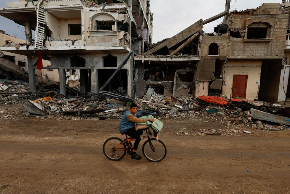 加薩民眾在停火後騎腳踏車在各處廢墟中移動。路透社