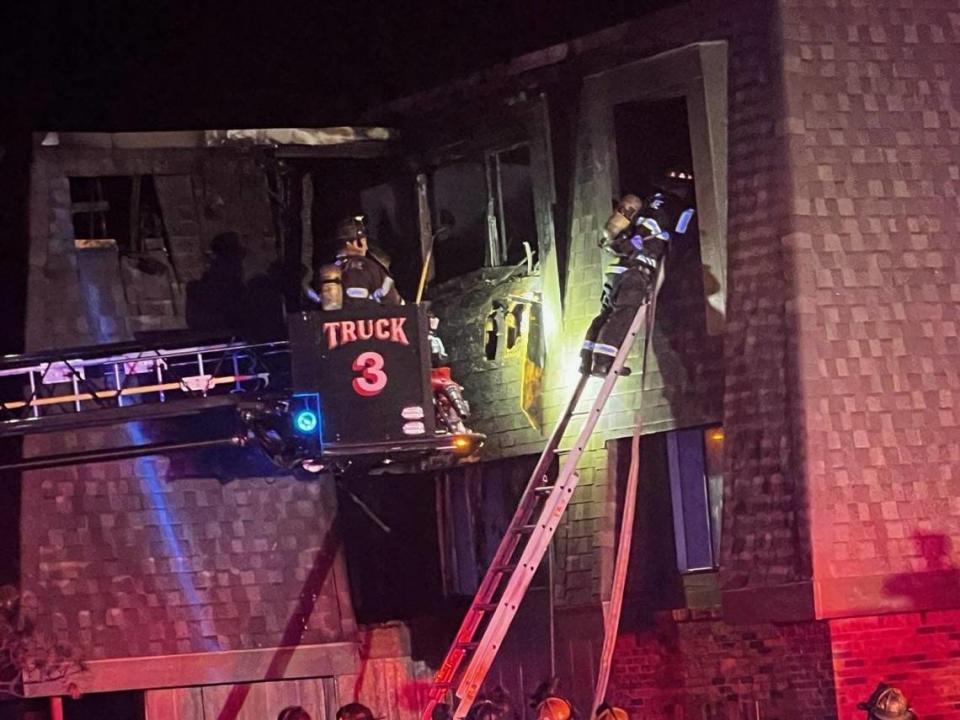 A Wichita firefighter searches through the window of an apartment complex where a fire killed a woman and injured three other people on Oct. 13.