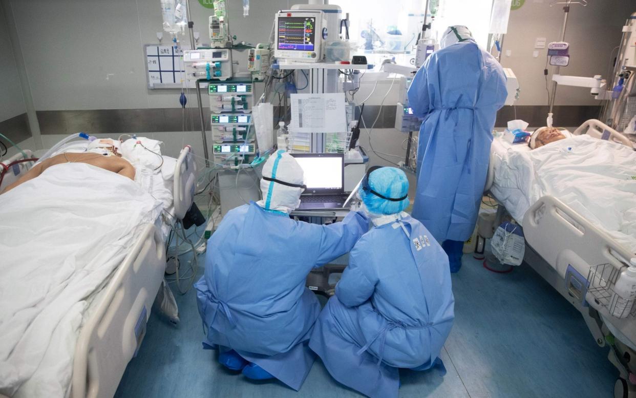 Medical staff treat Covid-19 coronavirus patients at a hospital in Wuhan, in China's central Hubei province - AFP