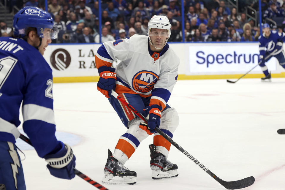 New York Islanders' Andy Greene defends against Tampa Bay Lightning's Brayden Point during the second period of an NHL hockey game Monday, Nov. 15, 2021, in Tampa, Fla. Greene was playing in his 1,000th NHL game. (AP Photo/Mike Carlson)