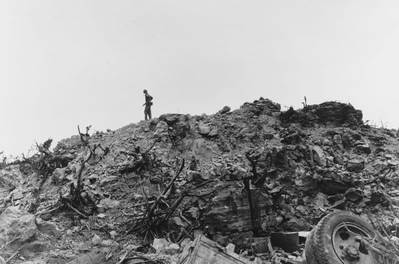 A U.S. Marine surveys the shattered landscape while hunting for remaining Japanese forces on Iwo Jima