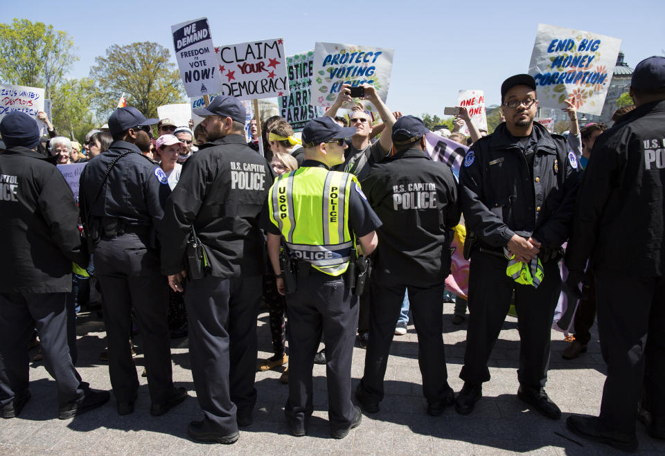 U.S. Capitol Police officers push back Democracy Spring protesters calling for the end of big money in politics from the Capitol steps on the East Plaza of the Capitol on April 13, 2016.