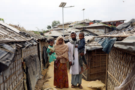 Kalim Ullah, his wife Taiyeba Begum and their children who take shelter in their relatives' tent to avoid forced repatriation, pose for a picture at a camp in Cox's Bazar, Bangladesh, November 14, 2018. REUTERS/Mohammad Ponir Hossain