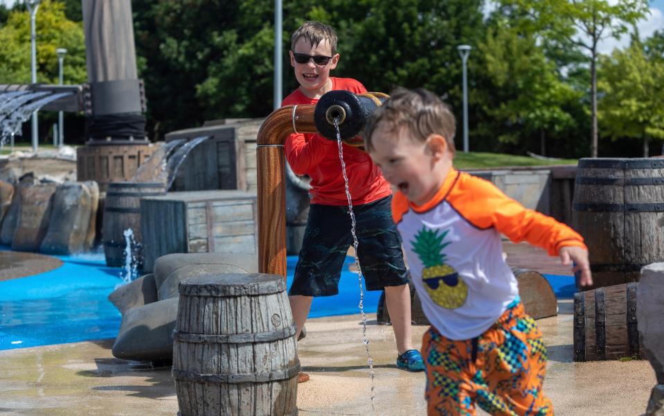 Matthew Owens, 8, attempts to wet his brother Patrick Owens, 2, with a water cannon at the Gilbert Family Schooner Splash Pad in Detroit on Friday, July 21, 2023.